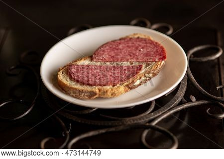 Bread With Salami On A White Plate On A Dark Background. Simple Sandwich.