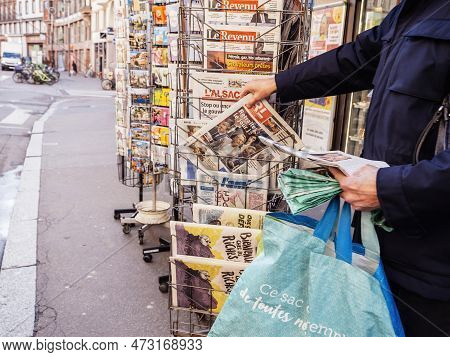 Paris, France - Mar 20, 2023: Senior Buying At Press Kiosk With Multiple French Press Newspaper Feat