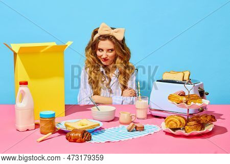 Portrait Of Funny Redheaded Girl Wearing Bow And Grimacing Simbolizing Dislike To Food On Pink Table