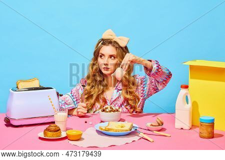 Food Pop Art Photography. Sad Young Girl With Long Curly Hair Preparing Milk Flakes With Hungry Eyes