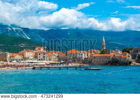 Landscape Of Sandy Brijeg Od Budva Beach And Old City Walls Fortress. Architecture Of Old Town Budva