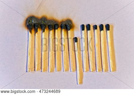 Row Of Burned Wood Matches Interrupted By One Standing Out. Concept Of Power Of Difference.