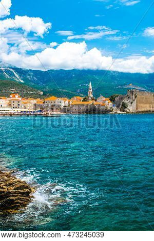 Landscape Of Sandy Brijeg Od Budva Beach And Old City Walls Fortress. Architecture Of Old Town Budva