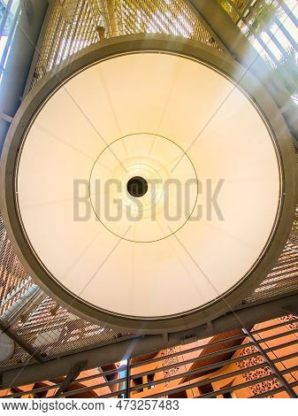 Uae, Abu Dhabi - 13th March, 2023: Wind Tower Underneath Low Angle View And Surrounding Buildings In
