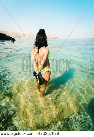 Back View Pretty Tourist Woman Stand In Clear Turquoise Water In Persian Gulf Mirellas Island. Oman 