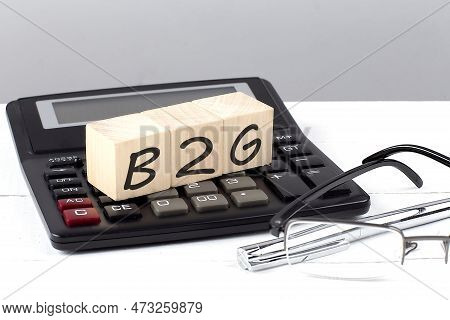 B2g Concept On A Wooden Cubes On Calculator On White Background