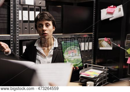 Woman Investigator Showing Crime Scene Photos On Tablet Computer, Discussing Criminal Investigations