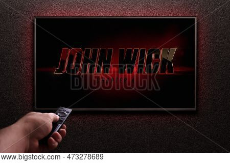 Tv Screen Playing John Wick Chapter 4 Trailer Or Movie. Man Turns On Tv With Remote Control. Moscow,