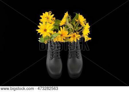 Black Women Platform Boots With Bouquet Of Yellow Jerusalem Artichoke Flowers, Black Background. Bea