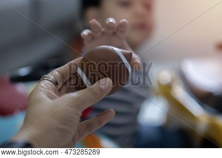 Close Up Hands Of Mom Holding A Ball With Little Asian Boy Play Throwing And Taking Ball. Concept Of