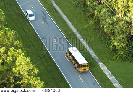 Top View Of Classical American Yellow School Bus Driving On Rural Town Street For Picking Up Kids Fo