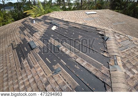 Wind Damaged House Roof With Missing Asphalt Shingles After Hurricane Ian In Florida. Repair Of Home