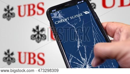 New York, Us, March 2023: Hand Holding A Phone With Credit Suisse Logo On Cracked Screen. Ubs Logo B