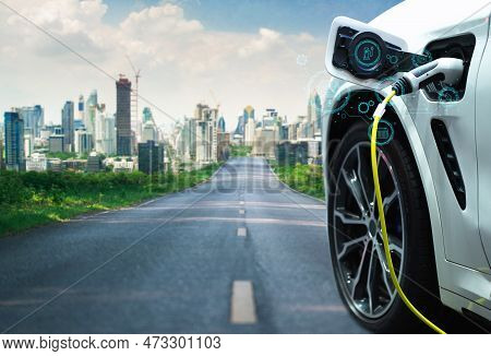 A Lengthy Road Leading To The City Of The Future And An Electric Vehicle At A Charging Station With 