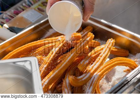 Chef Preparing Homemade Crunchy Churros With Powdered Sugar At Summer Outdoor Food Market - Close Up