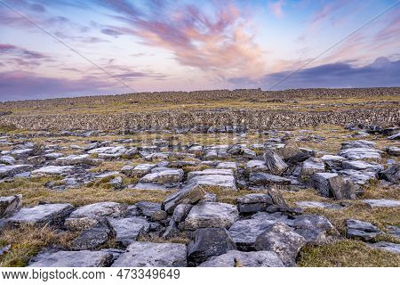 Inismore, Ireland Landscape With Rocky Meadows Uphill And A Morning Colorful Sunrise Sky With Pink C