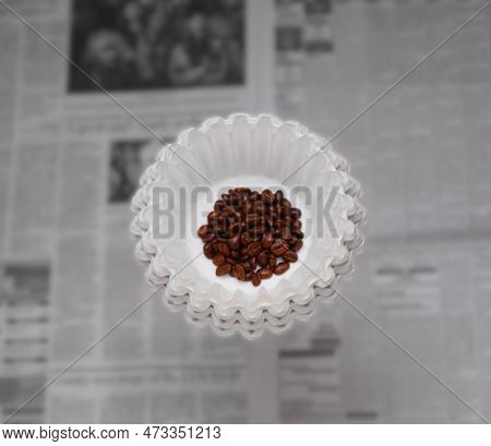 A Coffee Filter Is Holds A Small Mound Of Fresh Roasted Coffee Beans, Ready To Be Ground And Brewed