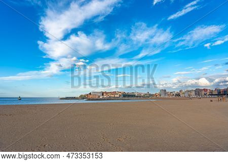 Larga Playa De Arena Dorada Junto A La Ciudad Costera De Gijon, Asturias, Spain.