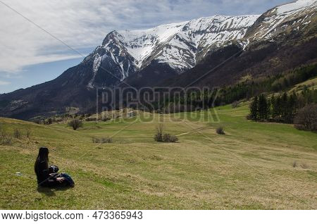 Montegallo, Italy - March 25, 2023: Portrait Of Woman Admiring The Mountains Landscape At The Feet O