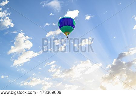 Colorful Hot Air Balloon Flying Over Blue Sky With White Clouds