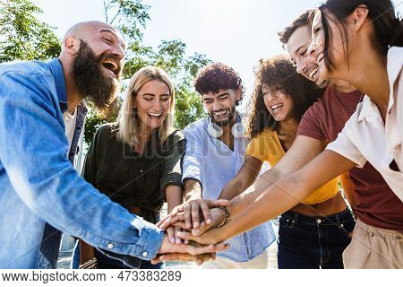 Multiracial Young People Stacking Hands Showing Unity. Diverse Group Of College Student Friends Join