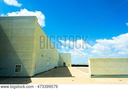Composition Of Blue Sky, White Clouds, Smooth Walls, And Stark Shadows