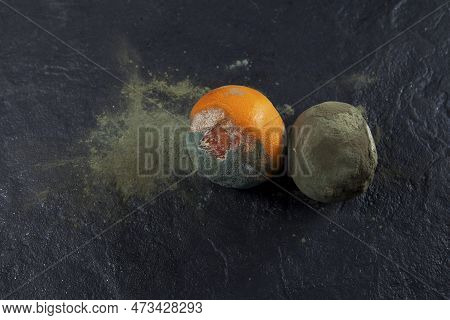 Two Rotten Oranges On A Dark Background. Incorrect Storage. Decomposition Process. Copy Space.