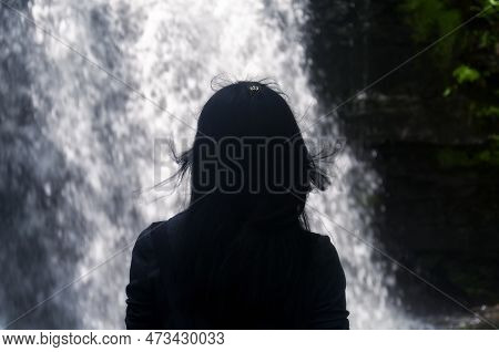 A Silhouette Of A Woman Looking At A Waterfall Within Bushkill Falls In Lehman Township, Pennsylvani
