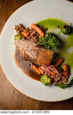 Close-up Top View On Plate With Piece Of Baked Pork Meat With Buckwheat And Vegetables And Sauce