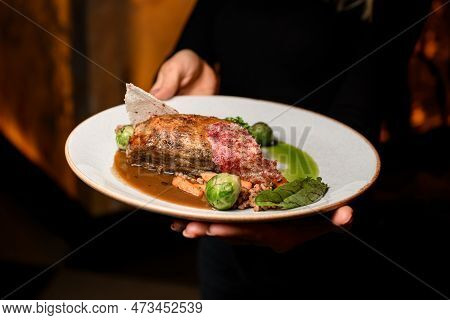 Close-up View On Plate With Piece Of Baked Pork Meat With Buckwheat And Vegetables In Female Hands