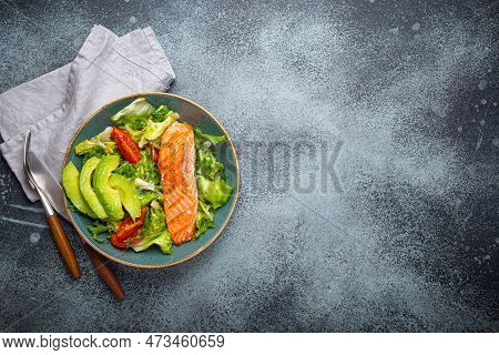 Grilled Fish Salmon Steak And Vegetables Salad With Avocado On Ceramic Plate On Rustic Stone Backgro