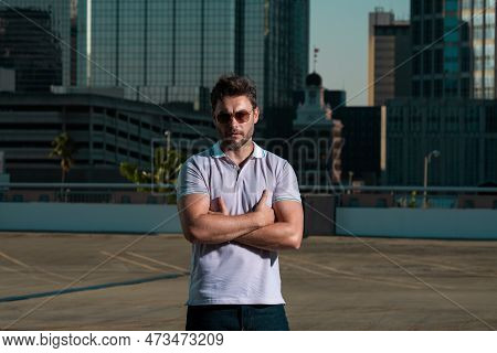 Handsome Man In Fashinable Outfit Walking On City Street. Successful Male Model In Big City Living T