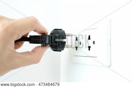 Hand Of Electrical Appliances He Was Pulling The Plug. Out Of The Plug. In His Office During Work Ho