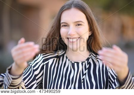 Front View Portrait Of An Elegant Woman Gesturing Come Here In The Street