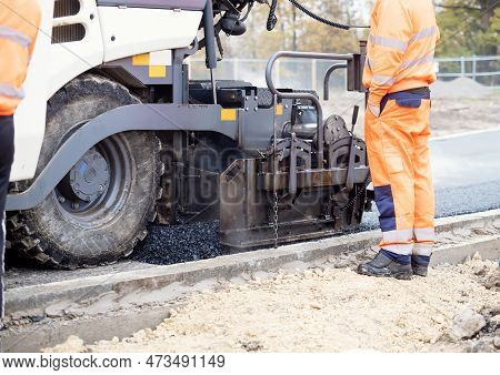 Asphalt Paver Filled With Hot Tarmac Laying New Road Surface On New Residential Housing Development 