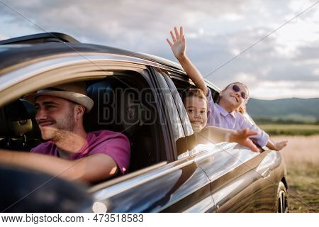 Happy Family Enjoying Drive In Their New Electric Car.