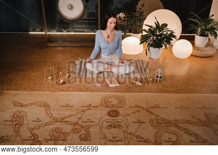 A Young Woman Sits In The Lotus Position Before The Start Of The Game Leela And Holds A Game Cube In