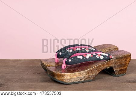 Japanese Traditional Geta Sandal On Pink Background. Traditional Japanese Asian Wood Footwear Called