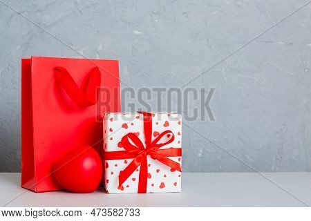 Shopping Bag With Gift Box On Colored Background Perspecrive View. Space For Text Holiday Concept.