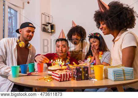 Multi-ethnic Group Of Friends At A Birthday Party On The Sofa At Home With A Cake And Gifts, Smiling