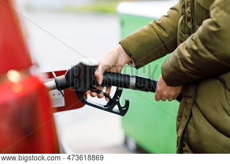 Close-up Of Hands Of Woman At Self-service Gas Station, Hold Fuel Nozzle And Refuel The Car With Pet