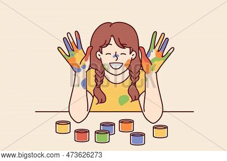 Positive Girl With Face And Palms Smeared With Multi-colored Paint Smiles, Wanting To Become Artist 