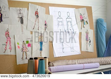 Pattern For Cloth Are Pasted On The Board In The Sewing Room. Rolls Of Cloth And Multi-colored Threa