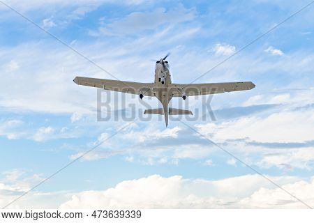 Single Engine Ultralight Plane Flying In The Blue Sky With White Clouds