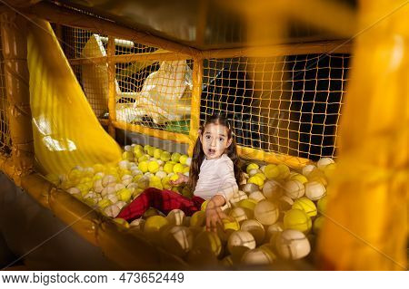 Little Girl Play With Colored Balls At Yellow Playground Park In Active Entertaiments.