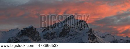 Bright Lit Clouds Over Snow Covered Mountains In Switzerland.
