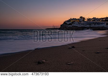 Beach And Calm Sea At Sunset With Golden, Purple And Red Sky. A Journey Along The Catalan Coast Of S