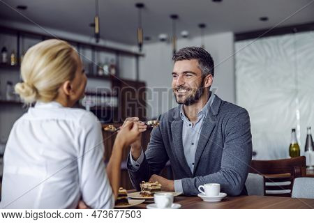 A Happy, Elegant Couple Is Sitting In The Restaurant And Having A Cake For Dessert. Sweet Love. Coup