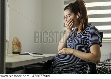 Pregnancy And Nausea. Home Office And Tired Pregnant Businesswoman. Woman Is Sitting In Front Of The
