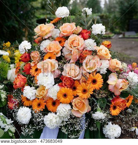 Stylish Funeral Flowers Of White Carnations, Orange Gerbera And Red And Pink Roses On A Grave After 